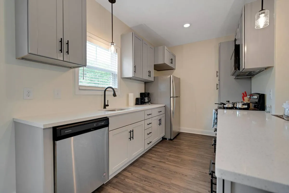A modern kitchen highlighted by a spacious island, stainless steel appliances, and elegant under-cabinet lighting. The open layout and stylish cabinetry create a warm, inviting atmosphere suitable for cooking, socializing, and family gatherings.