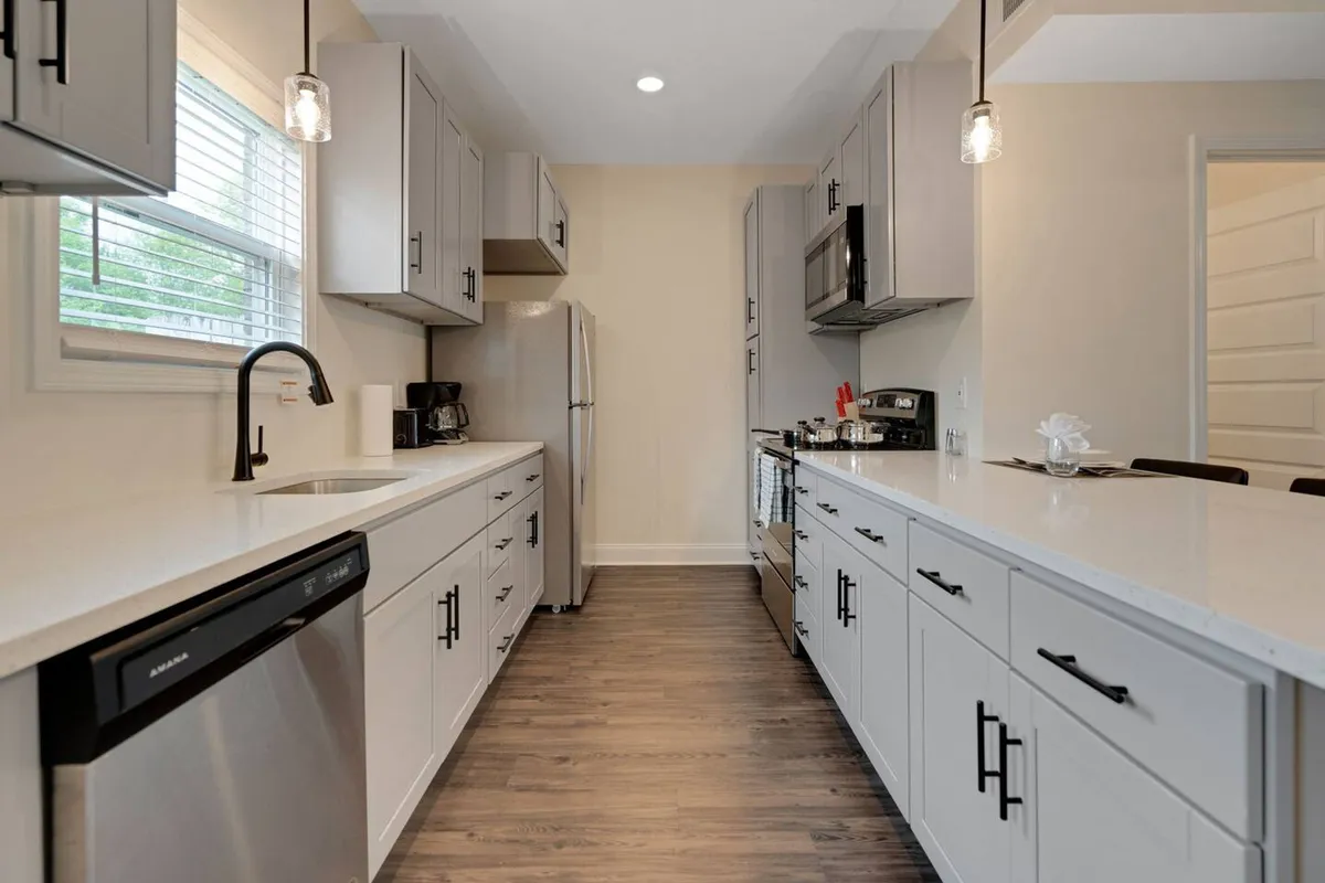 A bright, contemporary kitchen featuring a central island, sleek stainless steel appliances, and a window that lets in plenty of natural light. The space is arranged for both cooking and socializing, with clear surfaces and thoughtful details that make meal prep and gatherings easy.